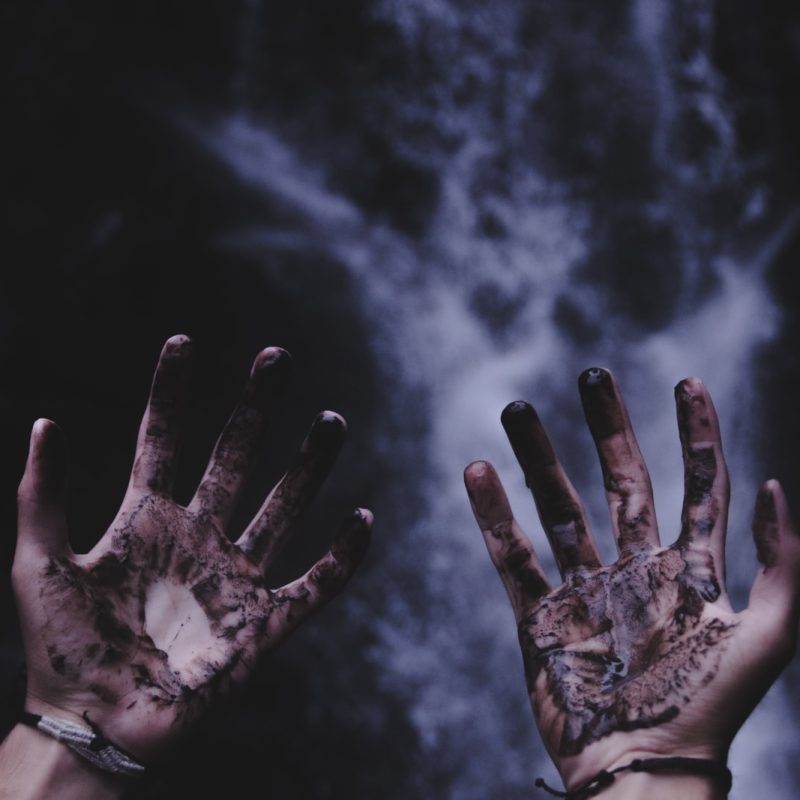 person hands with black liquids
