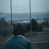 a person sitting on a swing with a hood on