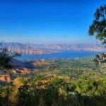 a scenic view of a lake surrounded by mountains