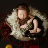 A baby sleeping in a basket with a christmas decoration